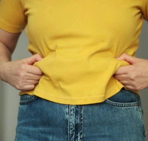 Cropped shot of a upset woman has overweight. she shows excess fat of the waist. she wants lose